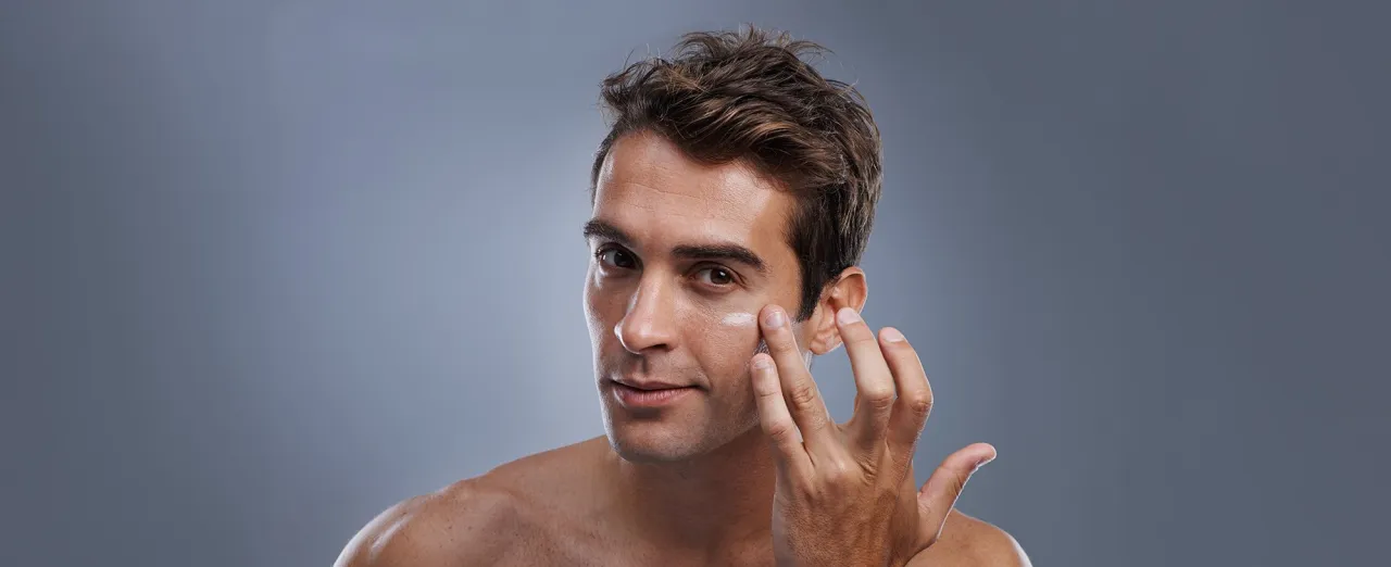 Mężczyzna nakładający krem nawilżający