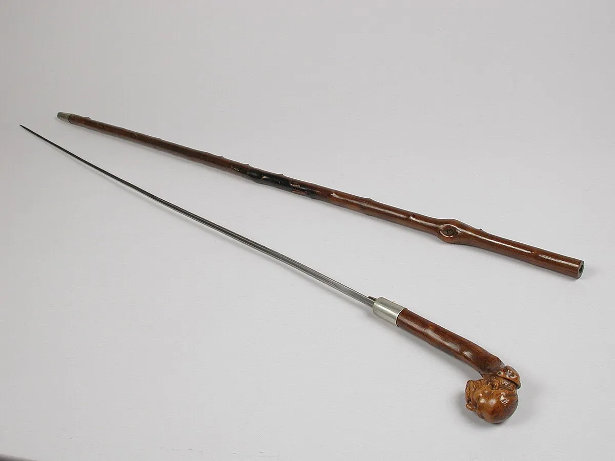 przykłady ostrzy ukrytych w przedmiotach (laska ze szpadą, nóż w sprzączce)