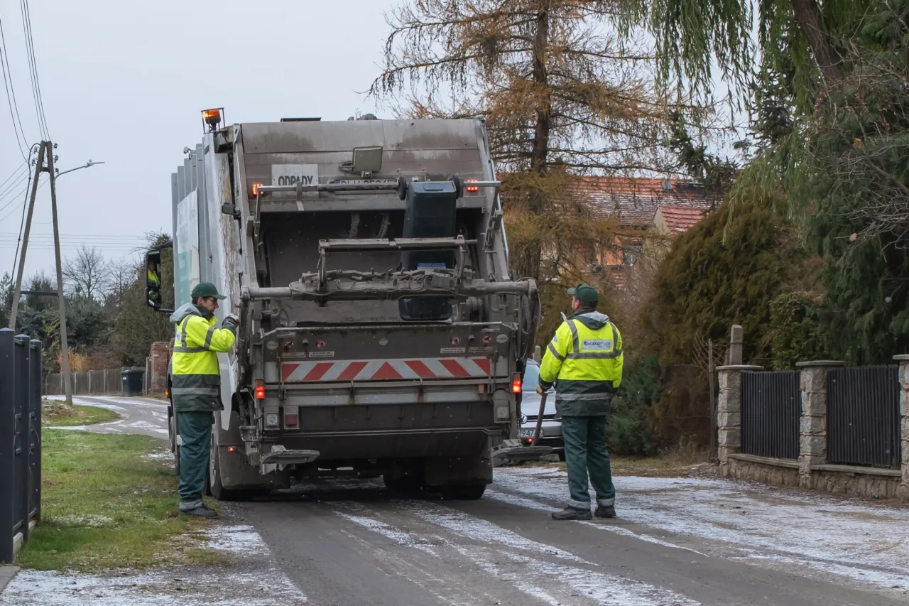 Kierowca śmieciarki opróżniający pojemnik