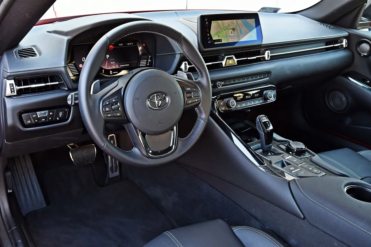 Wnętrze Toyoty Supry MK5. Kierownica, ekran nawigacji i panel środkowy. Zastanawiasz się, ile kosztuje Toyota Supra MK5?