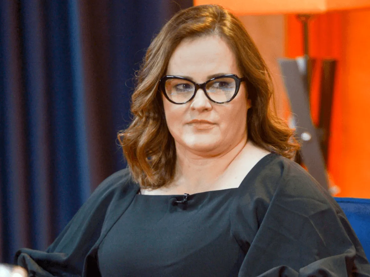 Joanna z kabaretu Hrabi w czarnej sukni z bufiastymi rękawami i okularach.