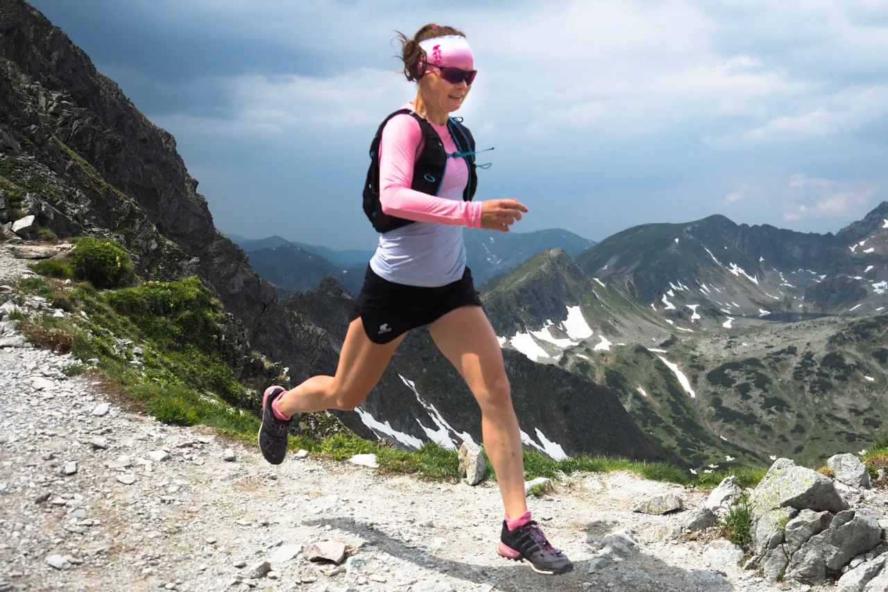 Biegaczka na szlaku górskim z widokiem, bieganie pod górę