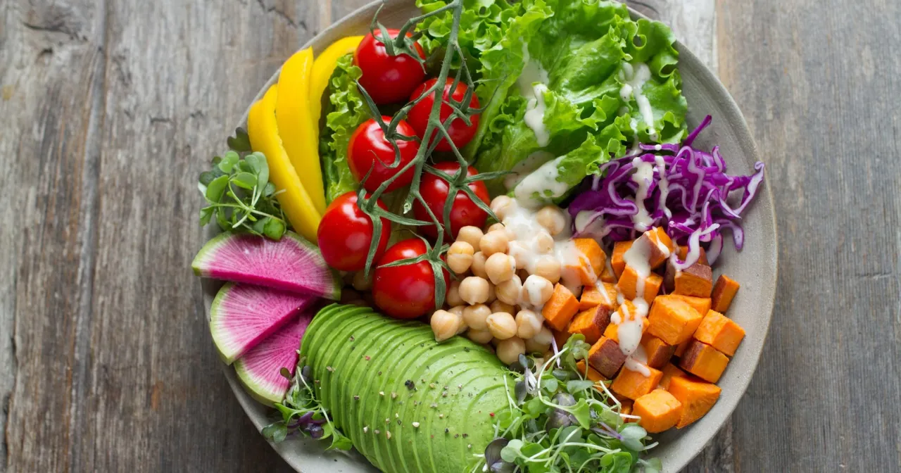 Kolorowa sałatka z awokado, ciecierzycą i batatami. Pytanie, ile można schudnąć na diecie wegetariańskiej, jest tu na drugim planie.
