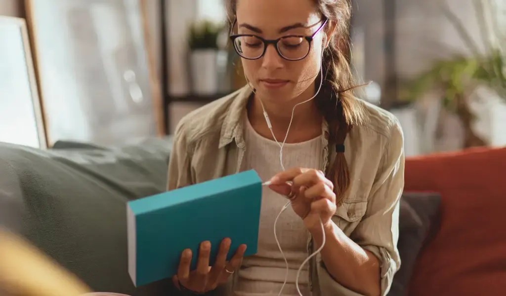 Osoba czytająca książkę lub słuchająca podcastu z notatkami