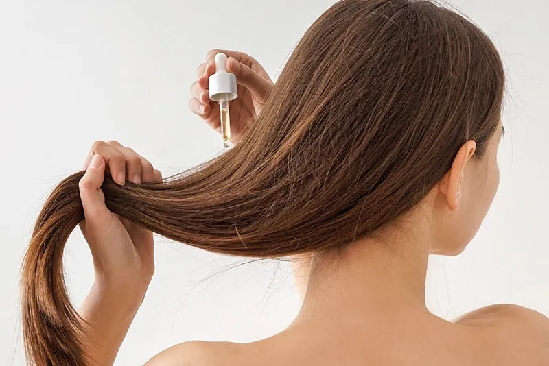 kobieta nakładająca serum na włosy, prawidłowa aplikacja serum