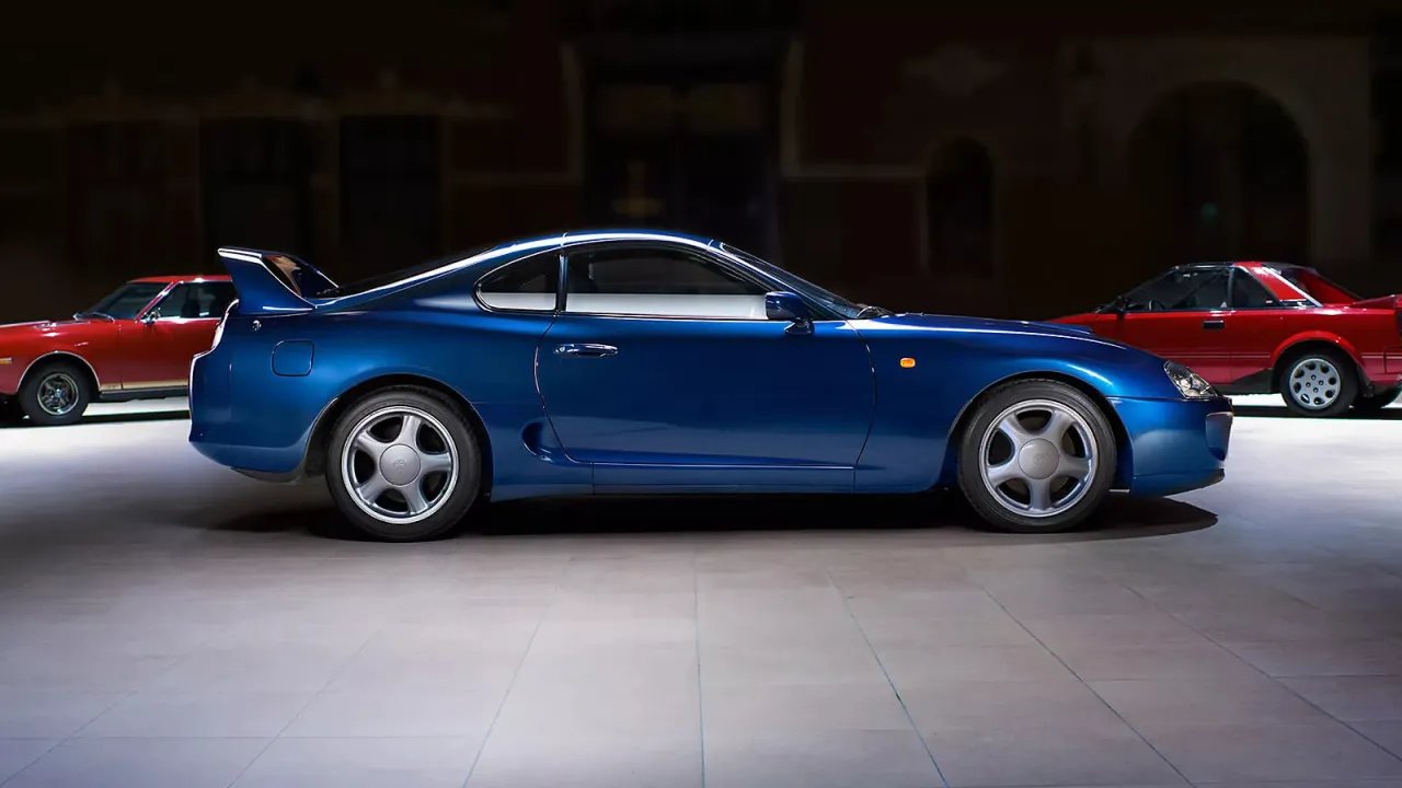 Niebieska Toyota Supra obok czerwonych klasyk&oacute;w. Zastanawiasz się, ile kosztuje Toyota Supra?