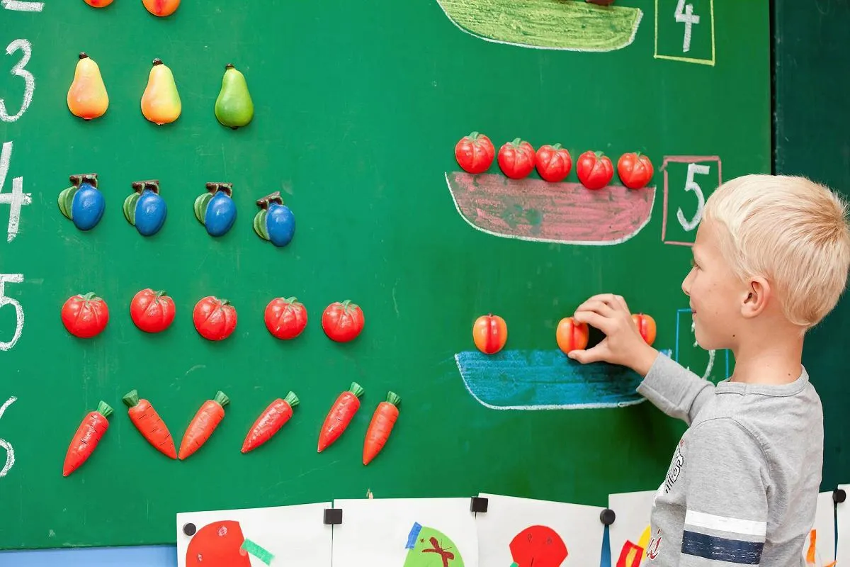 Znudzone dziecko przy biurku z podręcznikiem matematyki