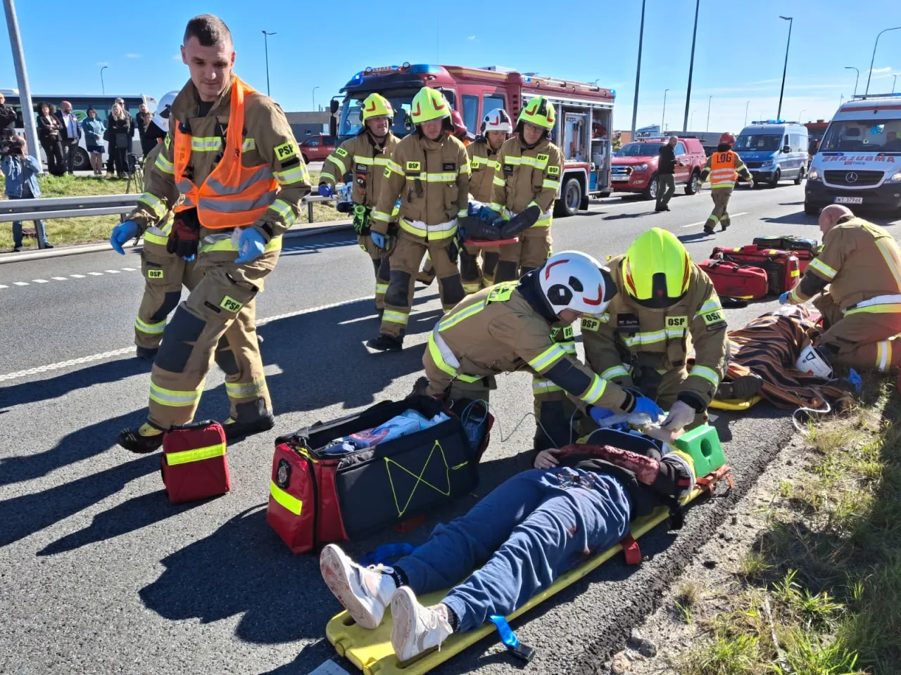 Strażacy i ratownicy medyczni współpracujący na miejscu zdarzenia