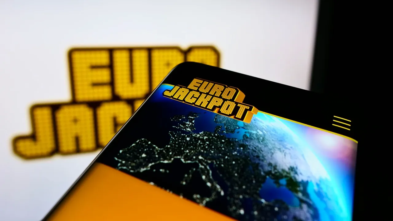 Ekran telefonu z logo Eurojackpot i mapą Europy nocą. Czekasz na wyniki Eurojackpot?