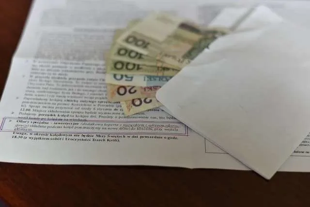koperta z pieniędzmi wręczana księdzu w kancelarii parafialnej
