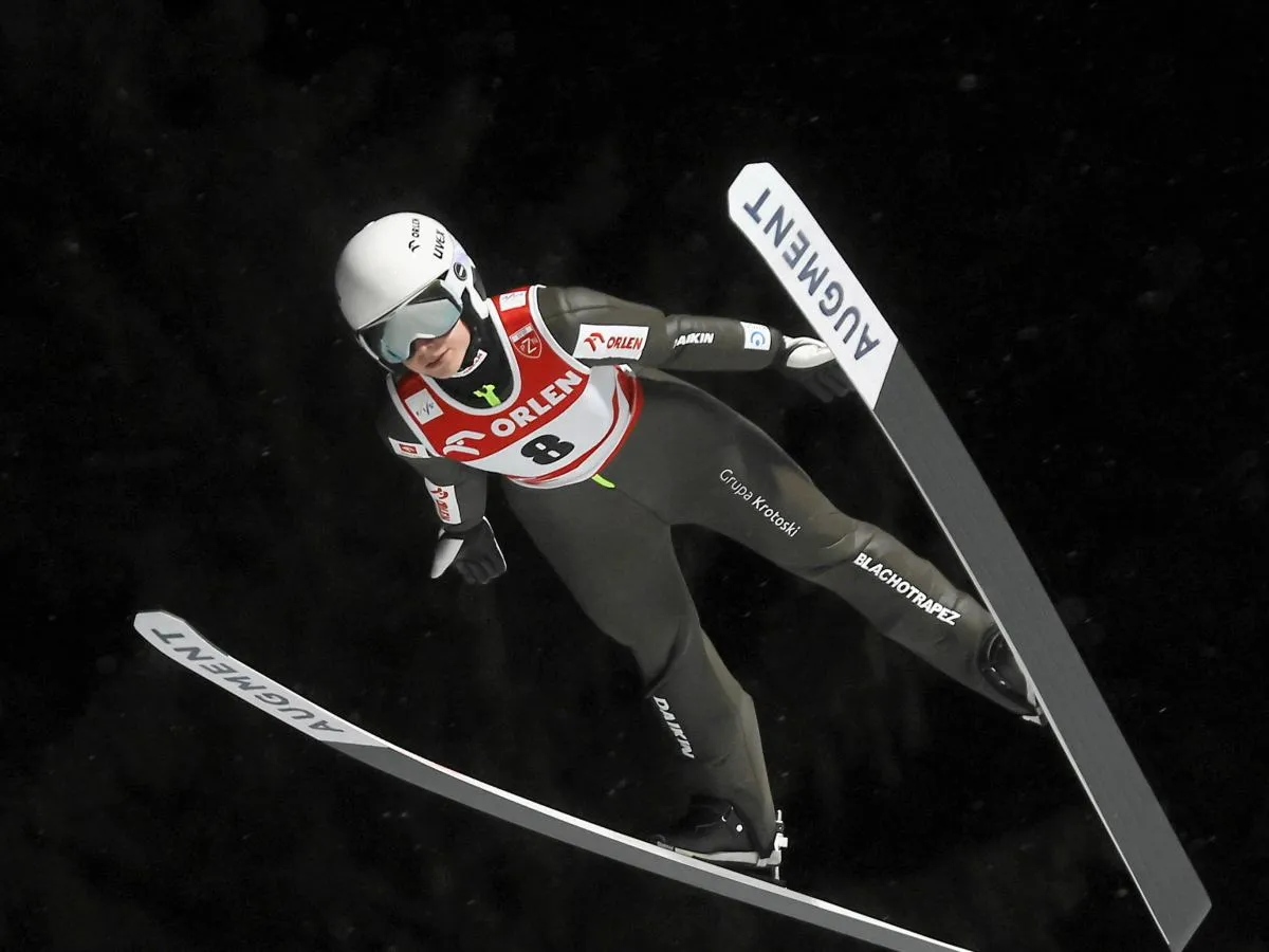 Skoczek narciarski w locie. Długie narty, które ważą niewiele, pozwalają mu szybować.