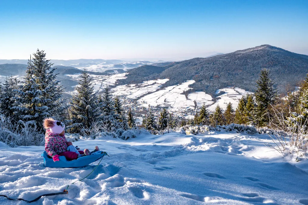 rodzina z dzieckiem na sankach w g&oacute;rach zimą