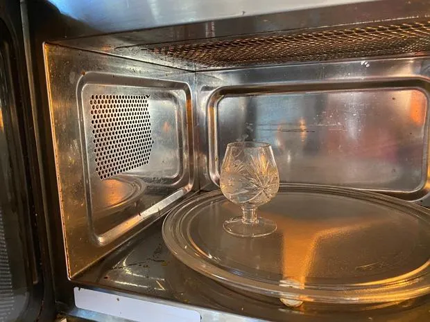 pizza w mikrofal&oacute;wce ze szklanką wody