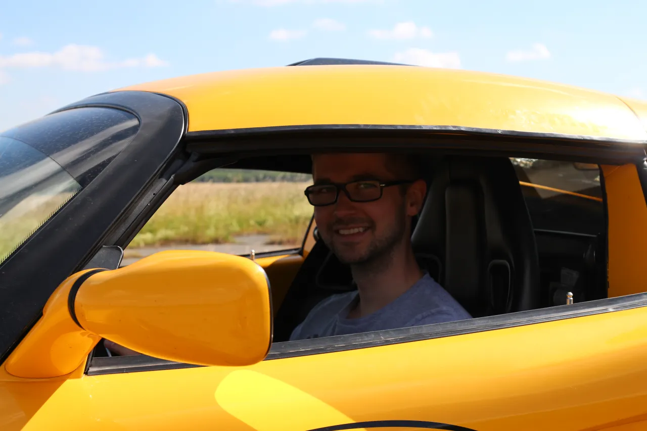 Mężczyzna jadący sportowym samochodem