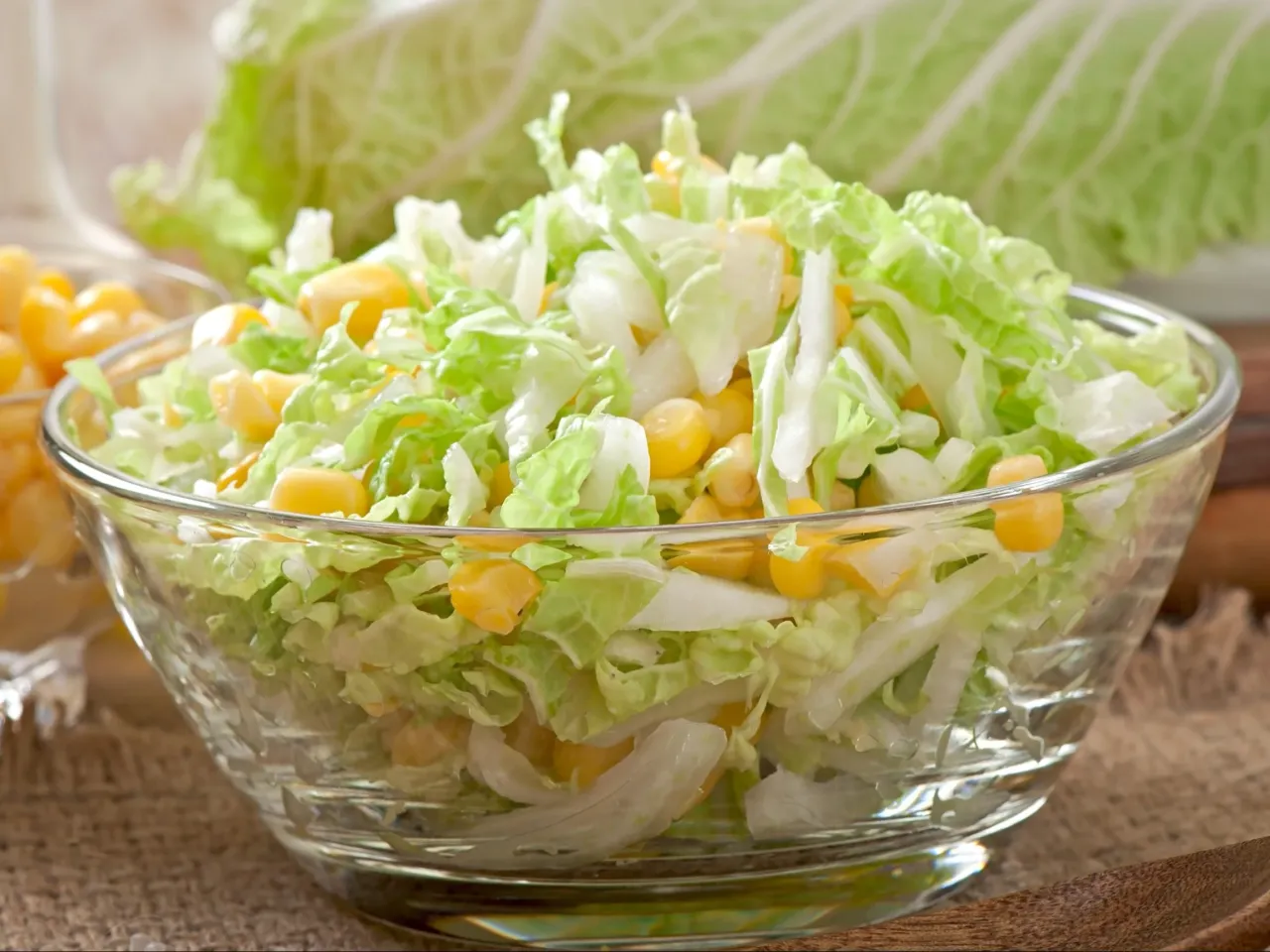 Pyszna surówka z kapusty pekińskiej i kukurydzy w szklanej misce. Idealna na lato, prosta do zrobienia.