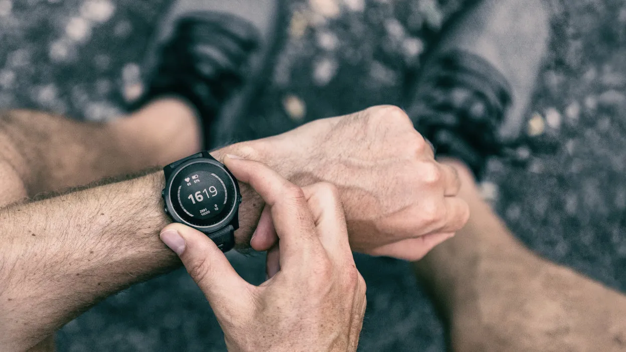 Biegacz mierzący czas na zegarku sportowym