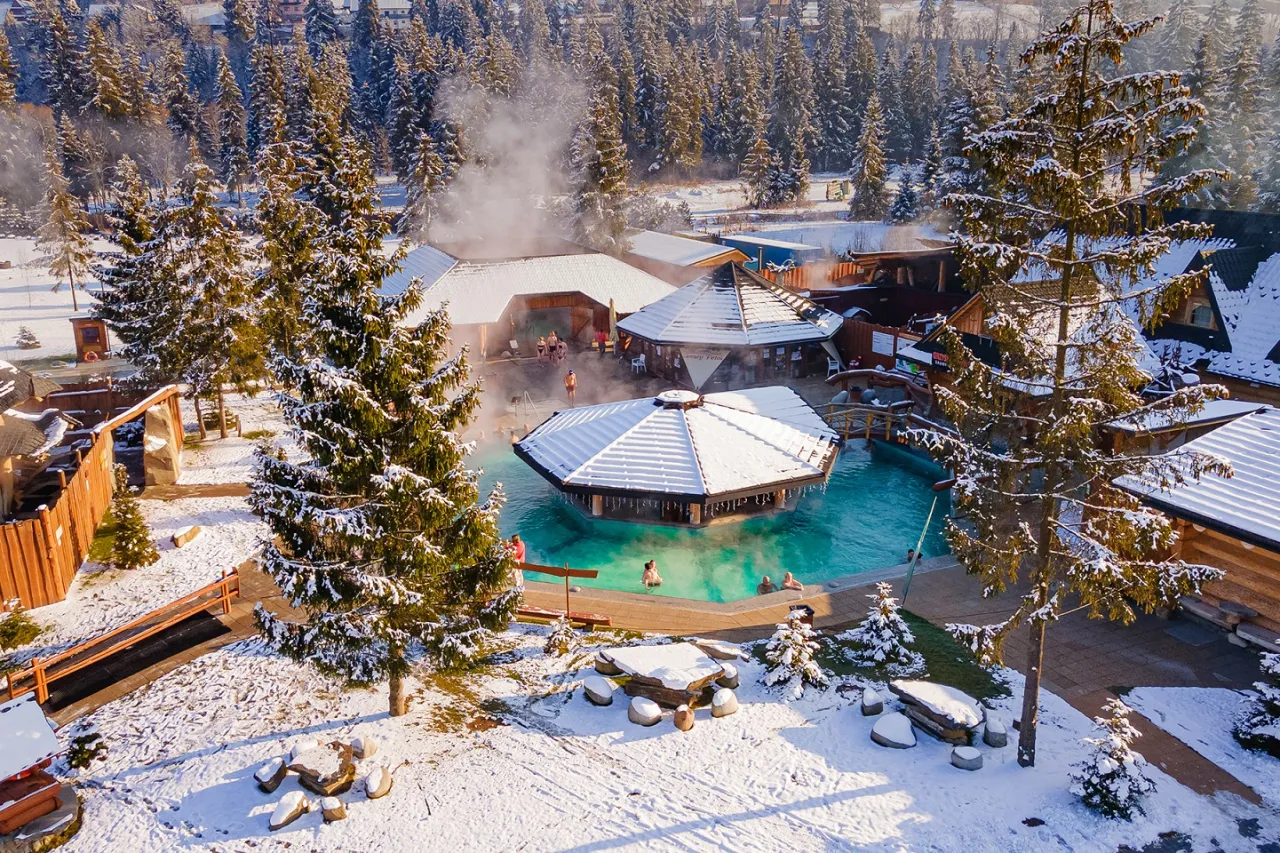 Zimowe termy w otoczeniu śniegu i lasu. Pomyśl, co zabrać na termy zimą: ręcznik, klapki i dobry humor!