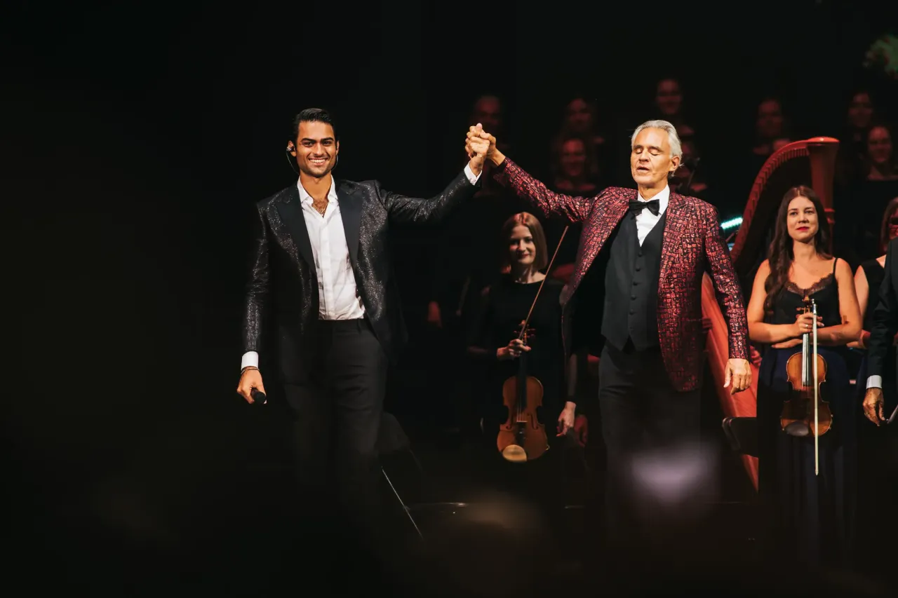 Andrea Bocelli i młody artysta pozdrawiają publiczność. Koncert odbył się w Warszawie.