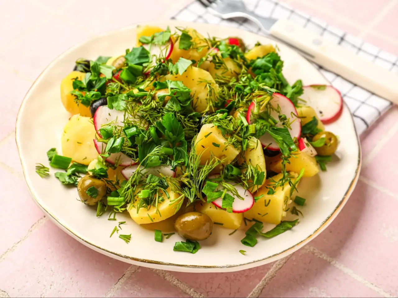 Sałatka ziemniaczana pysznie czy przepysznie? Kawałki ziemniak&oacute;w, rzodkiewki, oliwki i mn&oacute;stwo zi&oacute;ł tworzą apetyczną kompozycję.