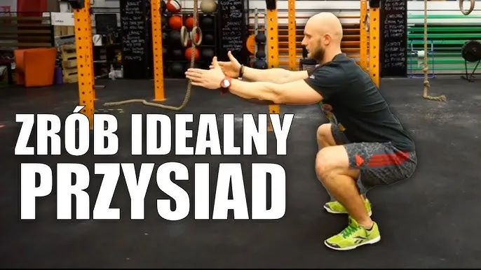 Trener CrossFit pokazujący prawidłową technikę przysiadu