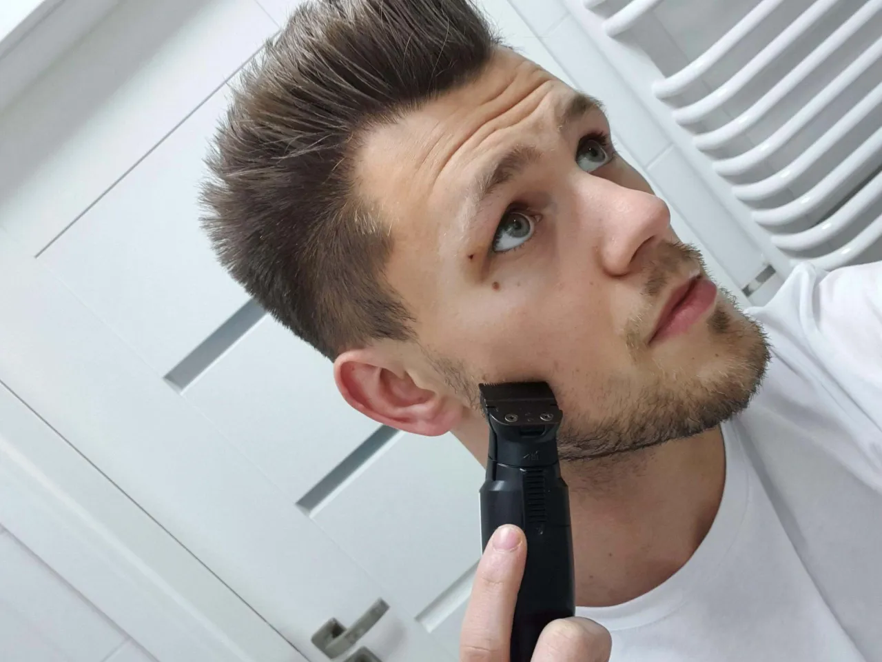 mężczyzna stylizujący zarost trymerem w golarce