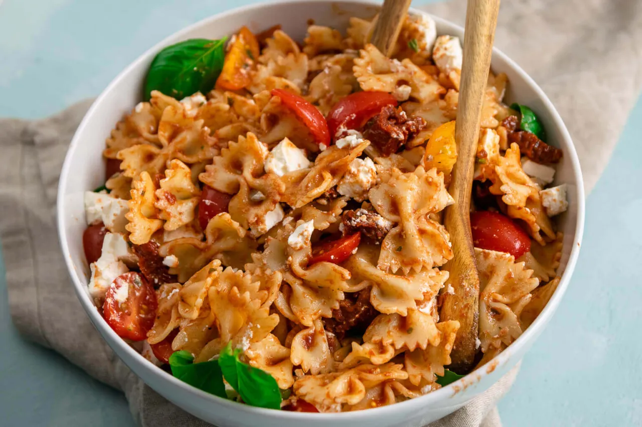 appetitlicher mediterraner Nudelsalat mit getrockneten Tomaten und Feta in einer Sch&uuml;ssel