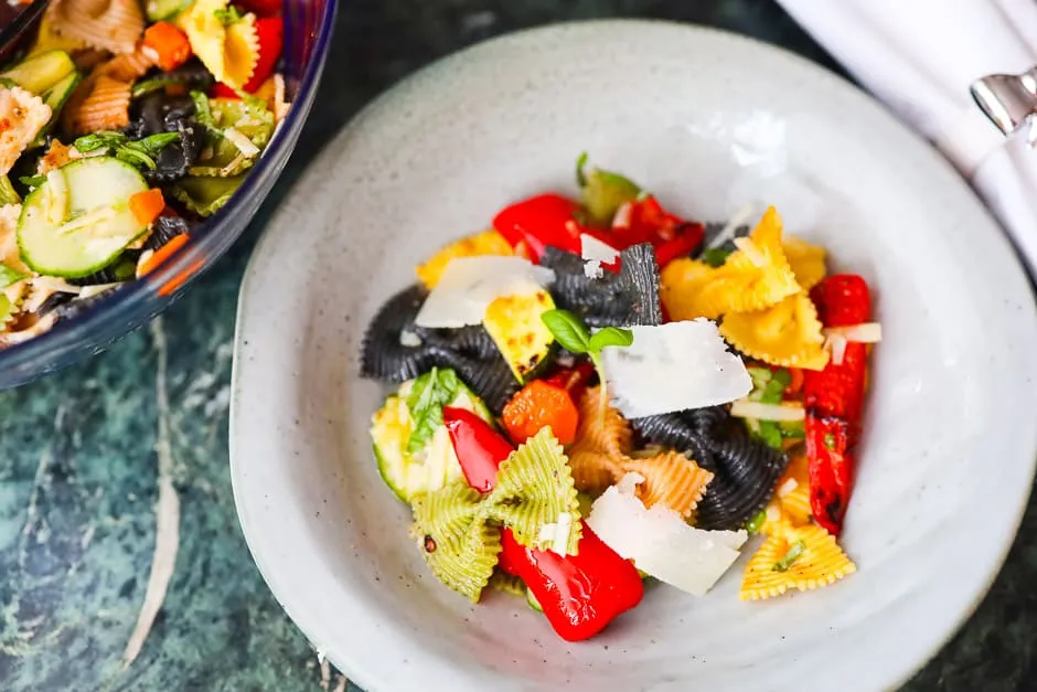 verschiedene bunte Nudelsalate in Sch&uuml;sseln angerichtet