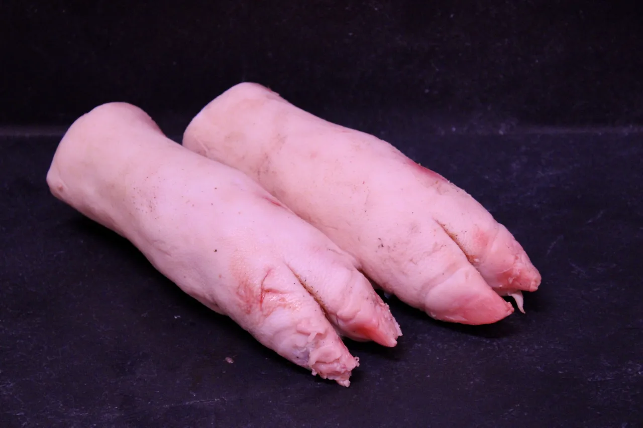 Dwie surowe nóżki wieprzowe, przednie czy tylne, gotowe do przyrządzenia.