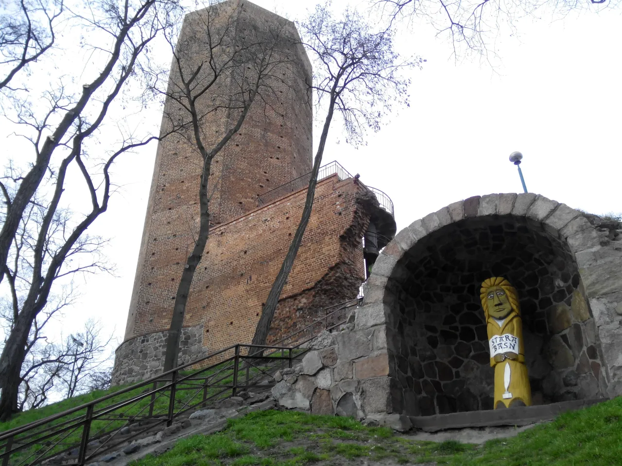 Kamienna wieża i drewniana figura nawiązują do legendy o mysiej wieży.