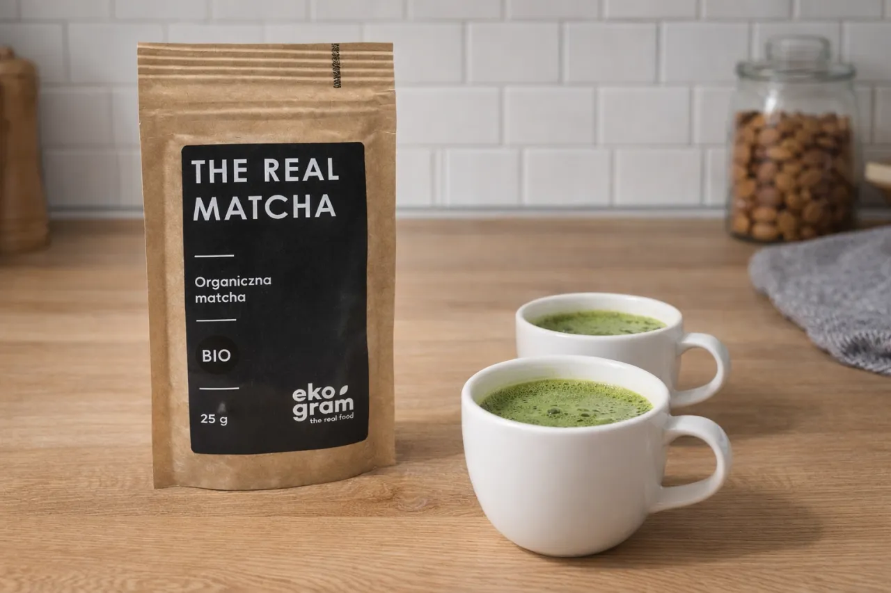 Dwie białe filiżanki z zieloną matchą obok opakowania 