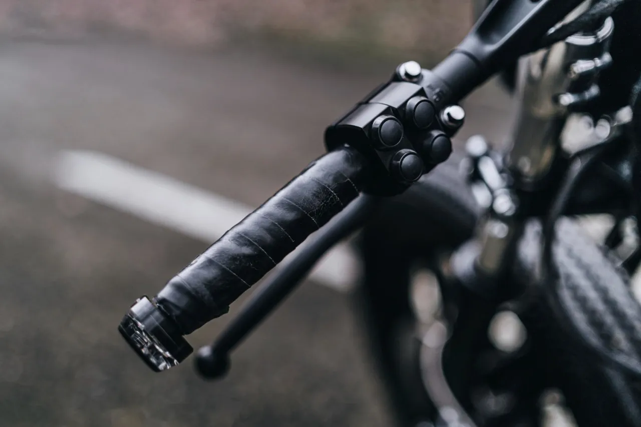 Czarna, owinięta taśmą kierownica z przyciskami. Idealna, jeśli zastanawiasz się, jaka kierownica do roweru trekkingowego będzie najlepsza.