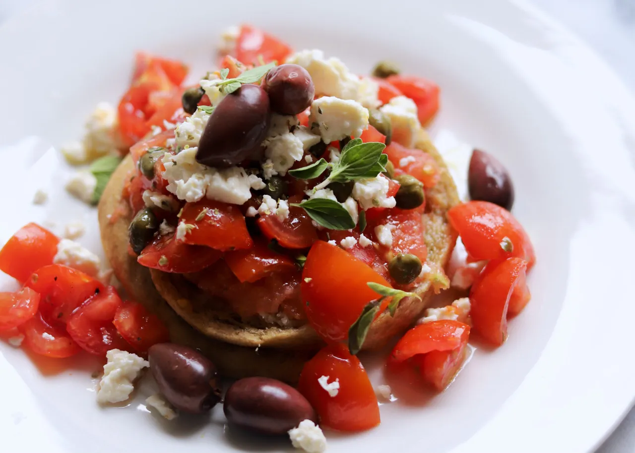 Dakos - grecka bruschetta z pomidorami, fetą, oliwkami i kaparami. Idealne pytanie: co zjeść na Krecie?