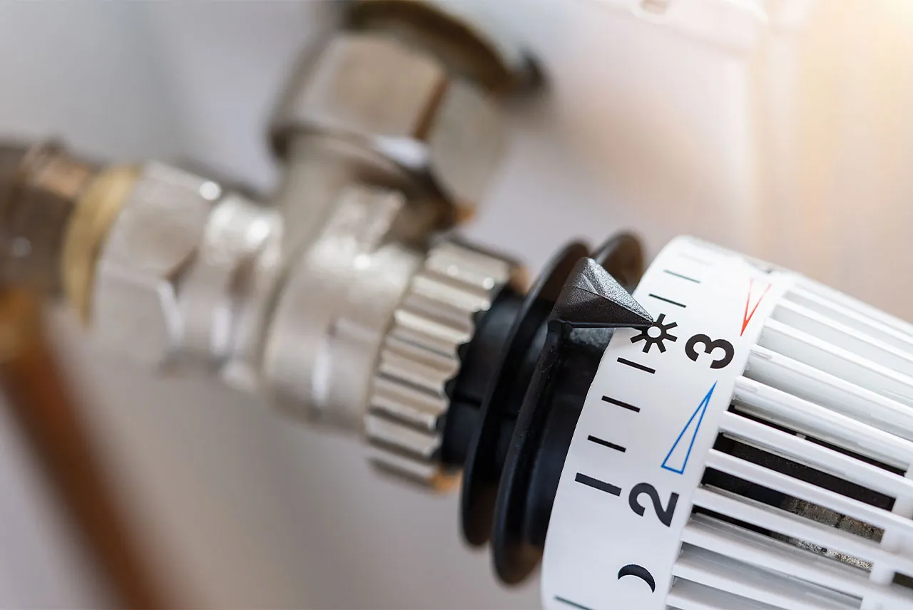 Zawór termostatyczny grzejnika z widoczną skalą od 1 do 3. Dowiedz się, jak zakręcić grzejnik bez pokrętła.