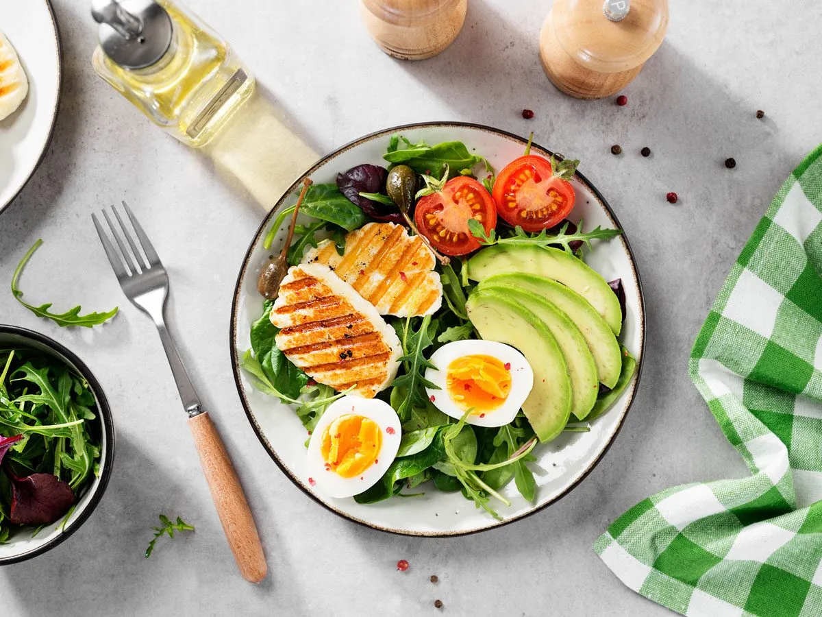 Sałatka z grillowanym serem, awokado, jajkiem i pomidorkami. Idealna na początek diety wegetariańskiej.