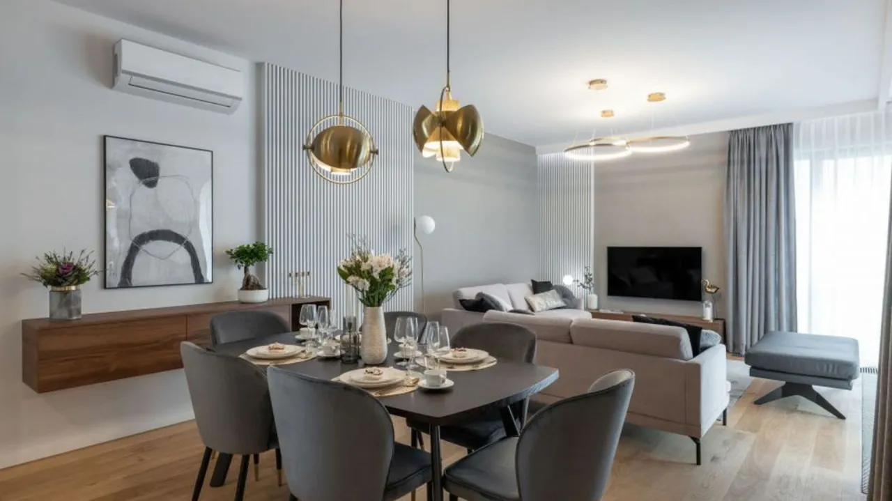 Nowoczesny salon z jadalnią: jak ustawić meble, by stworzyć funkcjonalną i stylową przestrzeń. Elegancka jadalnia z szarymi krzesłami i salon z wygodną kanapą.