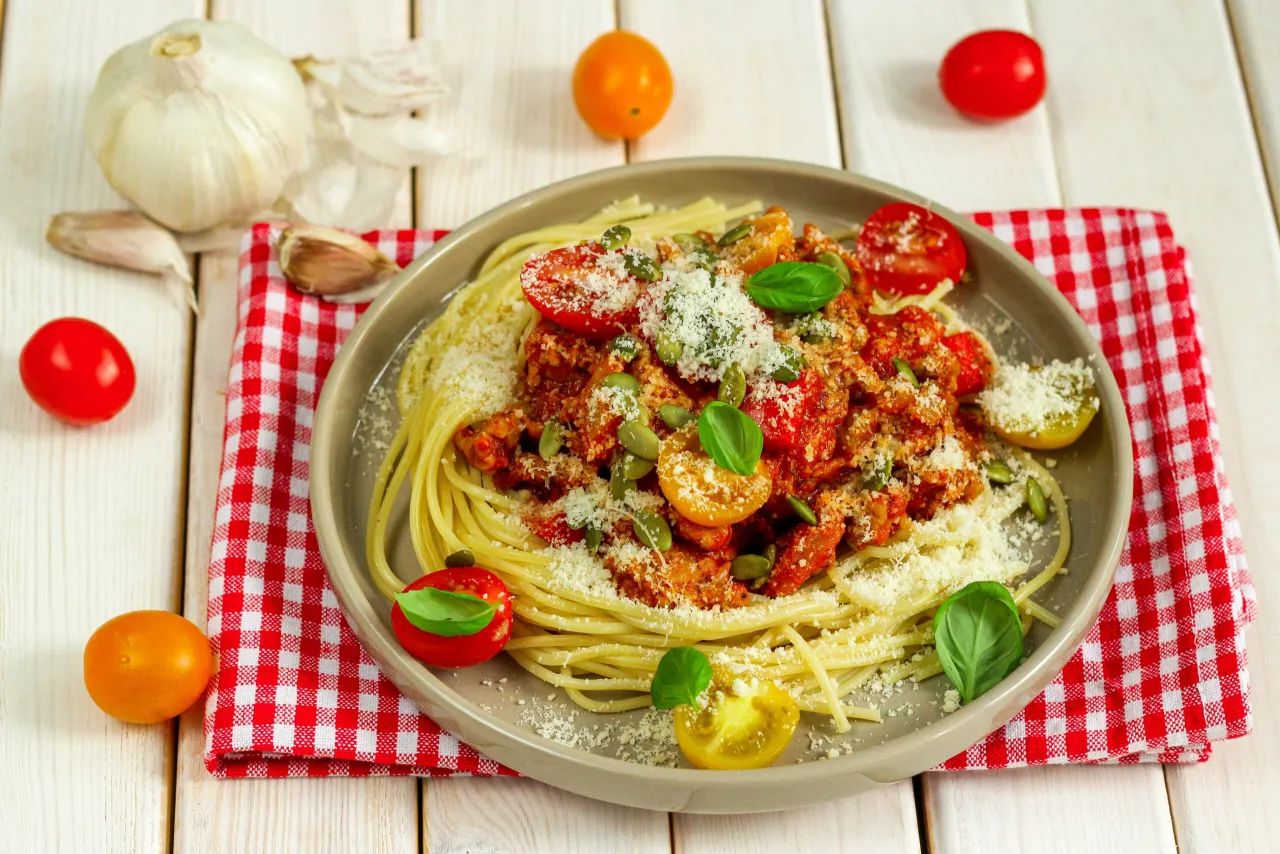 Pyszne spaghetti z mięsem mielonym i sosem pomidorowym, posypane parmezanem i pestkami dyni. Idealne, by dowiedzieć się, jak zrobić spaghetti z mięsem mielonym i sosem.