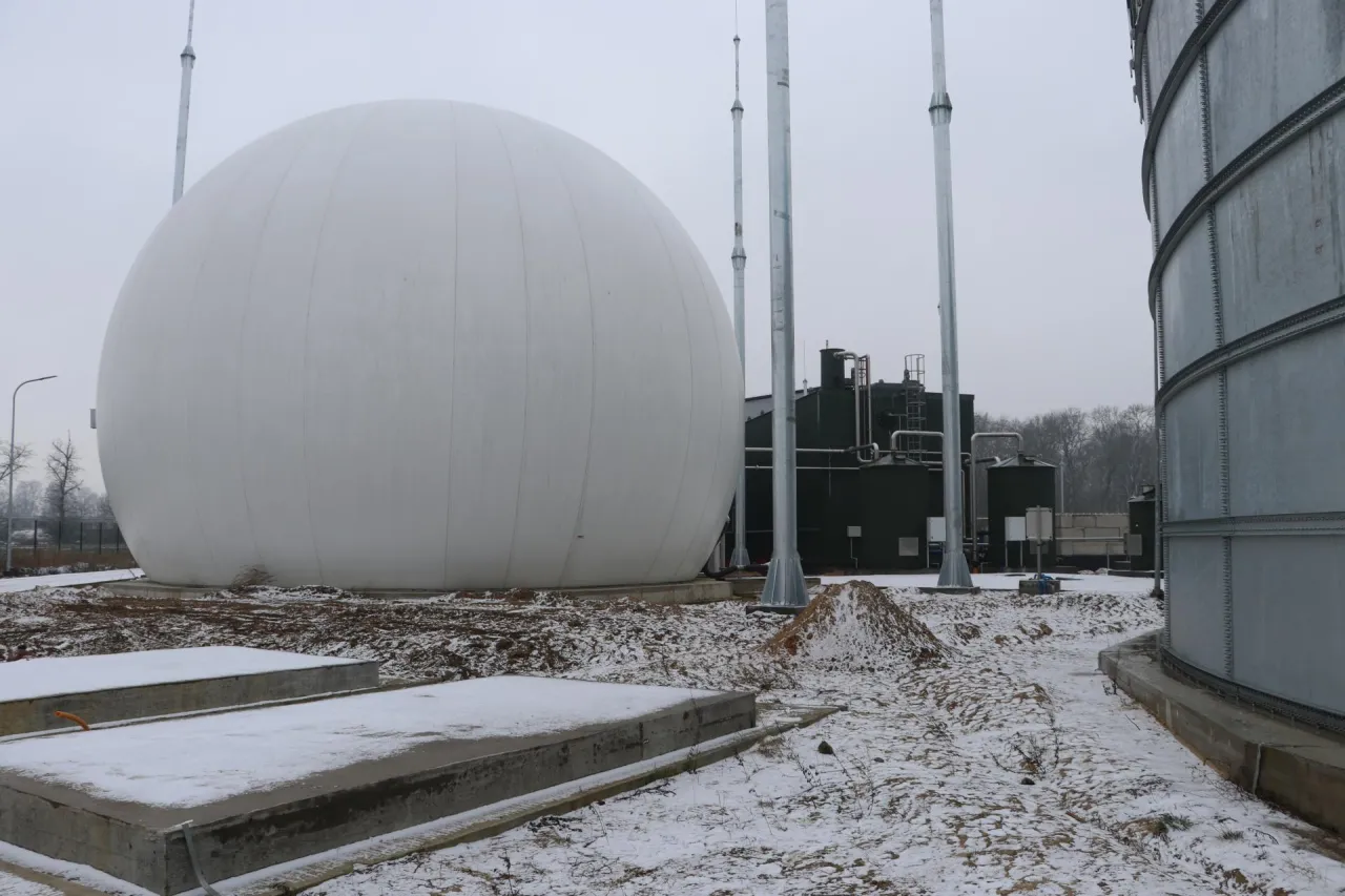 Ogromna biała kopuła biogazowni, obok metalowych silos&oacute;w. Czy biogazownia śmierdzi? Zimą teren wok&oacute;ł jest pokryty śniegiem.