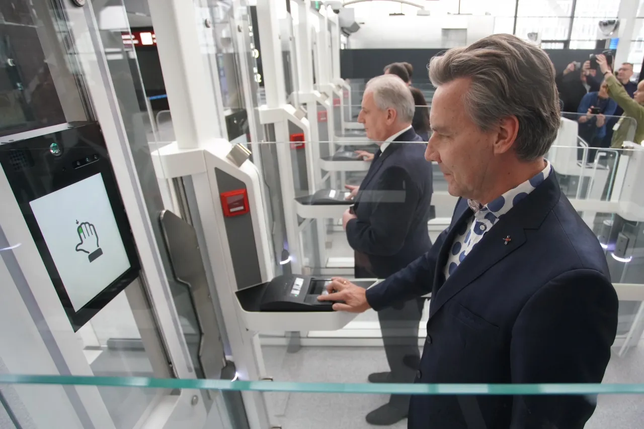 Mężczyzna w garniturze korzysta z automatu do odprawy online. Ile wcześniej na lotnisku? Tego nie wiemy, ale proces jest szybki.