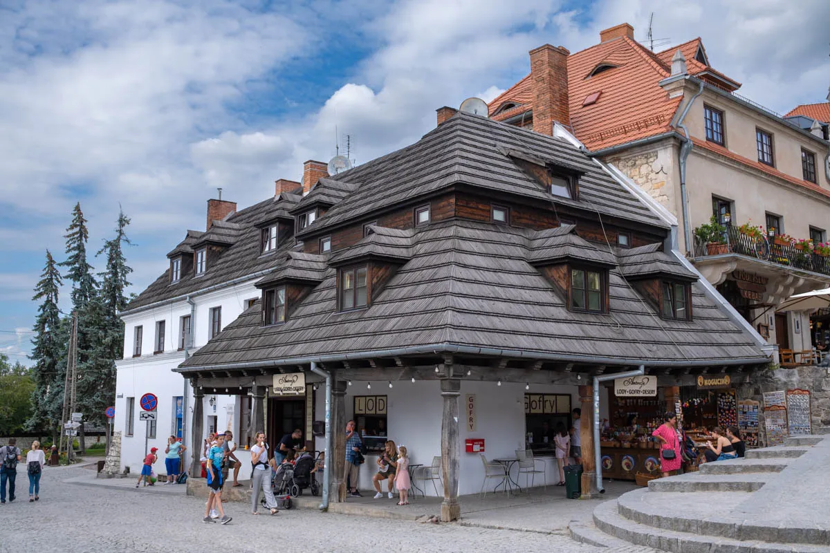 Kazimierz Dolny co zwiedzić? Urokliwy rynek z kamieniczkami i drewnianymi dachami, gdzie można kupić lody i gofry.