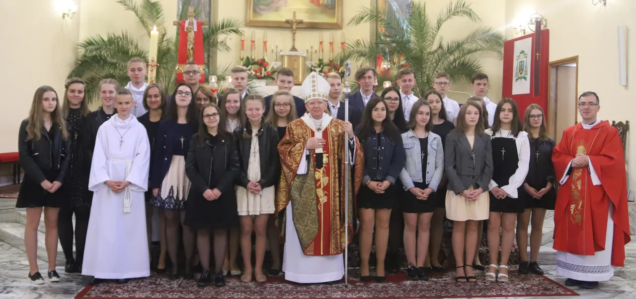 Młodzi ludzie w kościele, gotowi do bierzmowania. W której klasie jest bierzmowanie? To ważny sakrament dla tych młodych chrześcijan.