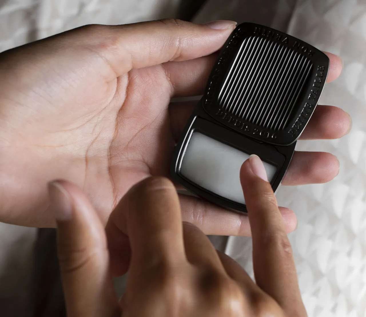 festes parfum in offener dose auf holzuntergrund