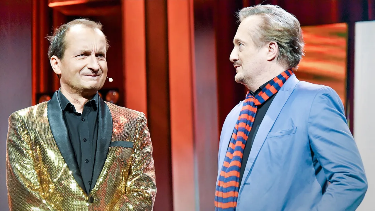 Dw&oacute;ch artyst&oacute;w Kabaretu Moralnego Niepokoju, jeden w cekinowej marynarce, drugi w błękitnym garniturze, szykuje się do kolejnych skeczy.