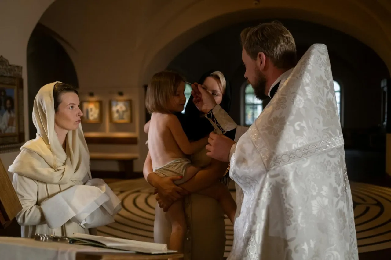 Chory w łóżku, rodzina obok, kapłan modlący się