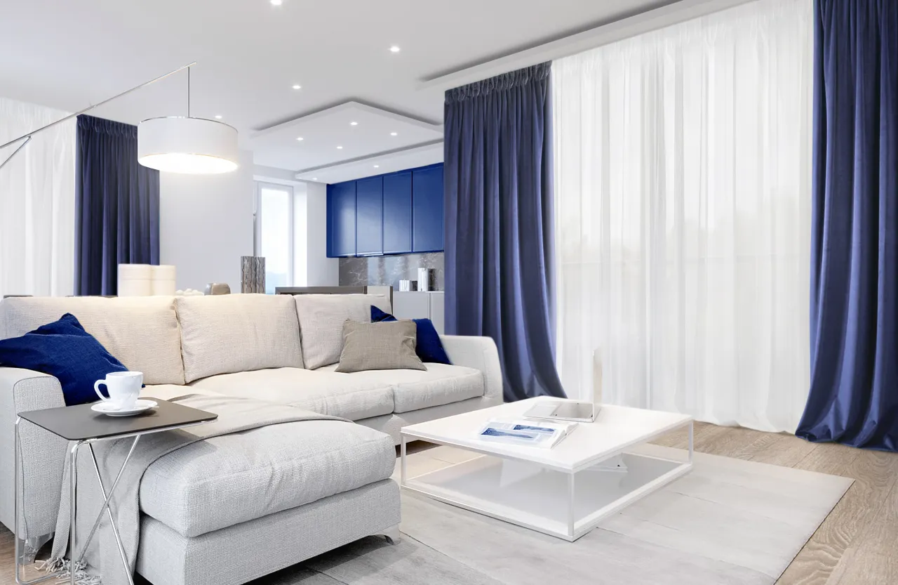 Nowoczesny salon z kanapą, stolikiem i zasłonami. Zastanawiasz się, ile żabek na metr karnisza?