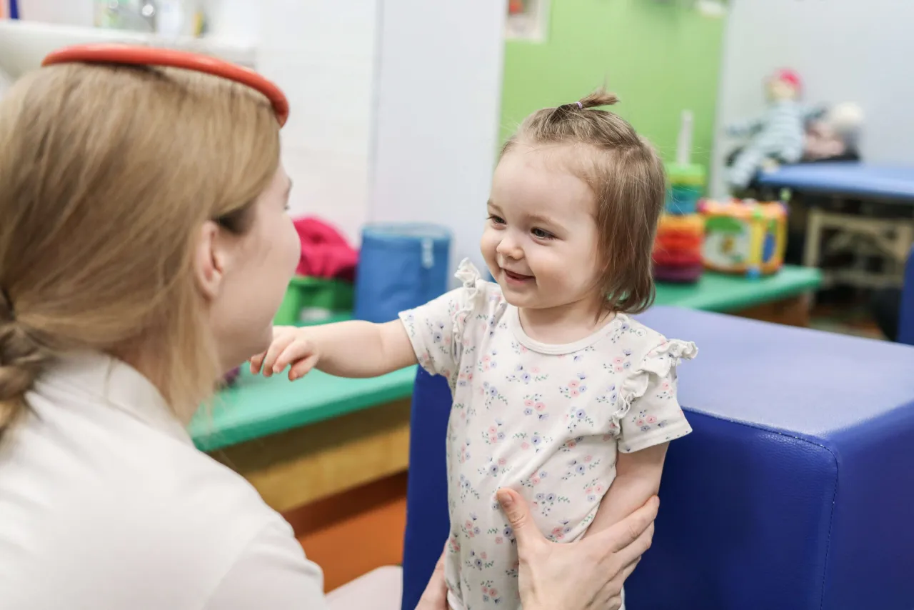 Dziecko z terapeutą SI podczas ćwiczeń na równoważni