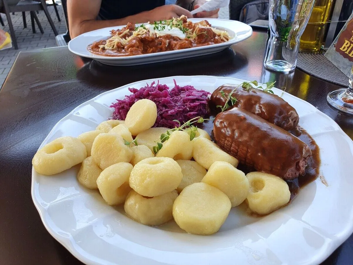 Dwa kotlety mielone w sosie z kluskami śląskimi i czerwoną kapustą. Idealne pytanie: gdzie na obiad?