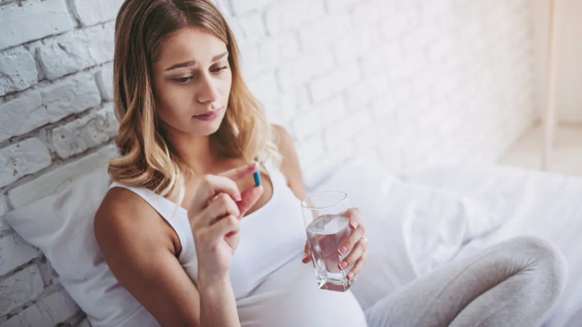 kobieta w ciąży z przeziębieniem, termometr, chusteczki