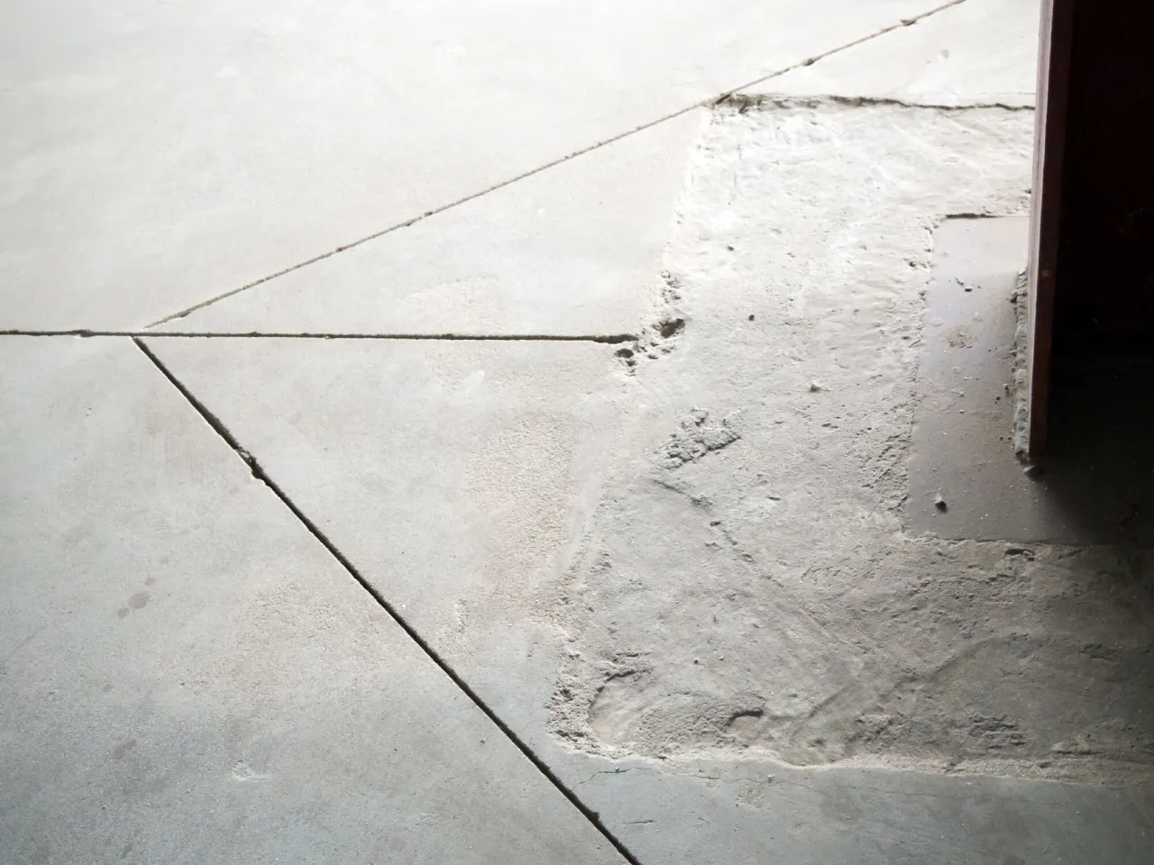 Nacięcia na wylewce betonowej, kt&oacute;re pomogą w prawidłowym wykonaniu dylatacji. Widać fragmenty wypełnione zaprawą.