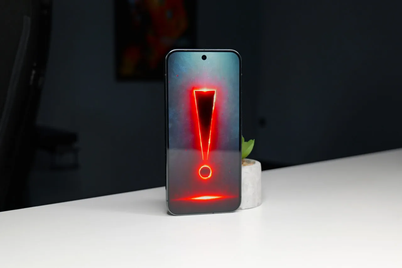 Telefon z wykrzyknikiem w czerwonej poświacie. Czy to ostrzeżenie przed włamaniem na telefon?