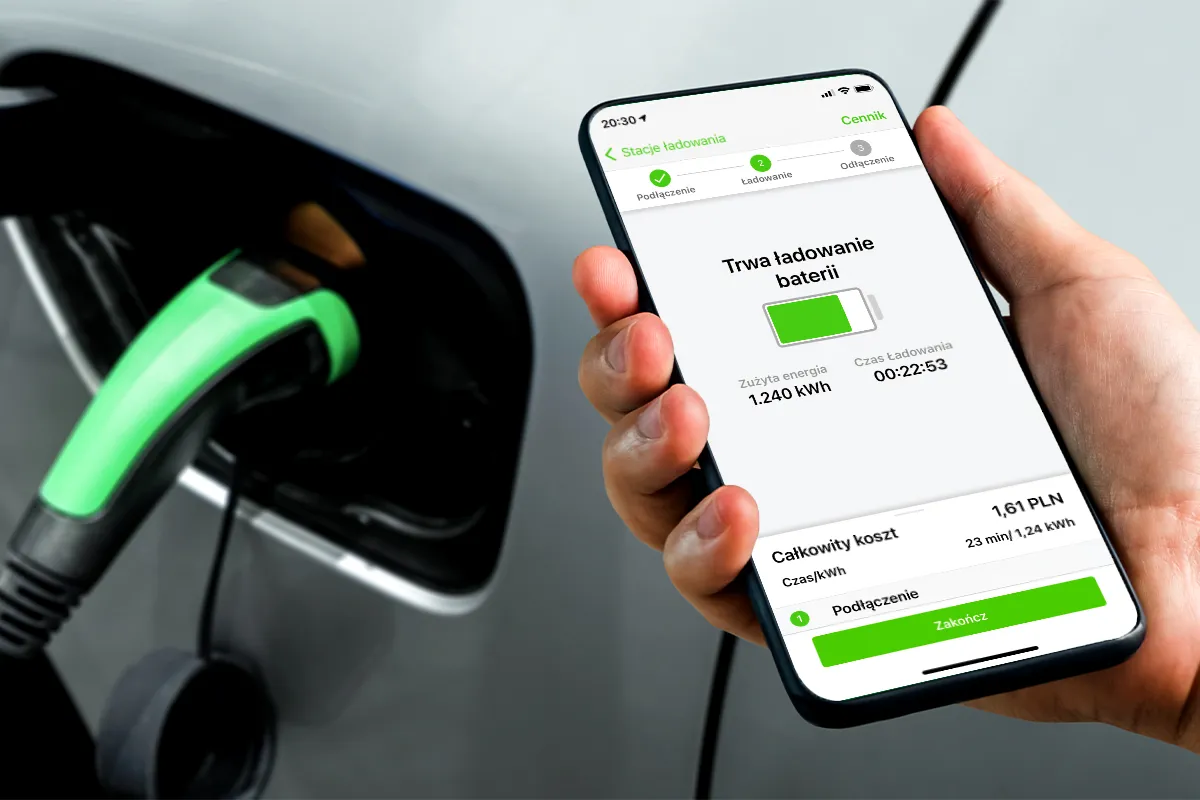 Elektryk ładujący się na stacji szybkiego ładowania, kierowca sprawdza telefon